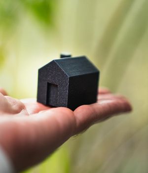 Hand mit Miniaturhaus